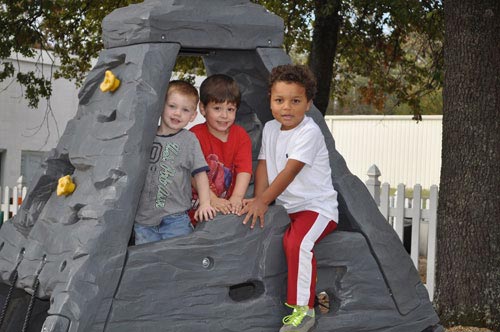 Three Children Playing in a Toy Mountain